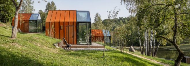 glass and weathered steel cabins on a hill
