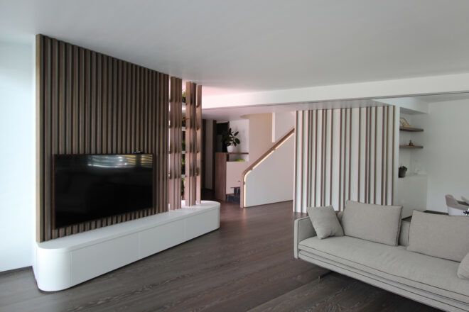 white sofa near wood wall with mounted TV