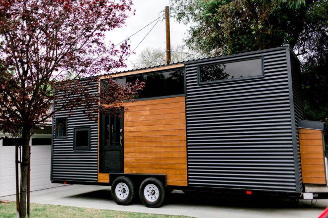 black metal and wood tiny home on wheels