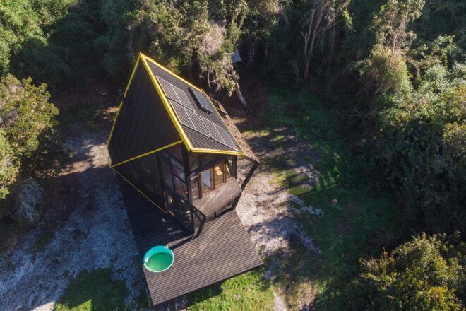 aerial view of wood cabin with hot tub on the deck