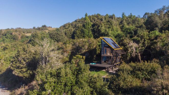 wood cabin with solar panels in a forest
