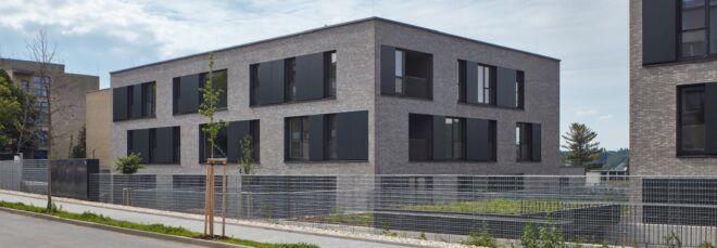gray building with large black square shutters near windows