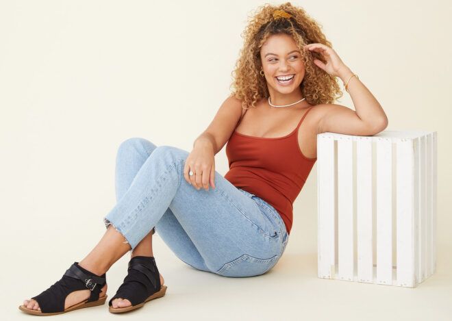 A person sitting on the ground wearing a pair of Balla4Earth shoes in Blacksands.