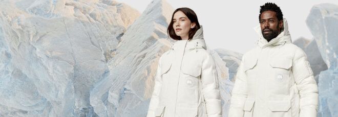 two people wearing warm white parkas