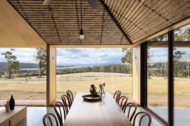 long wood dining table near glass wall