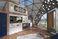 rendering of wall-mounted TV and small kitchen inside a geodome