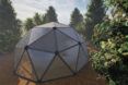 aerial rendering of geodesic dome covered in stone
