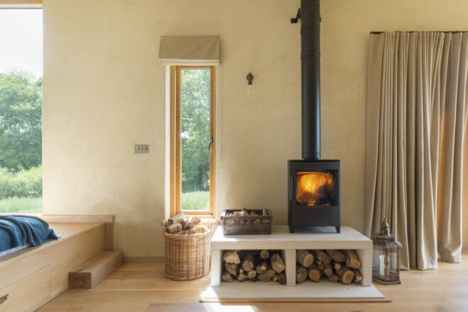 wood-burning stove on wood platform inside a cabin