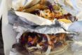 A pair of vegan tacos wrapped in foil.