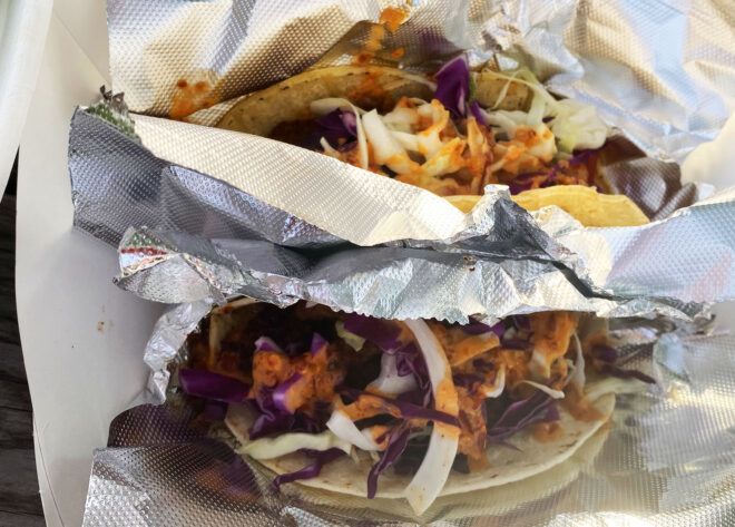 A pair of vegan tacos wrapped in foil.