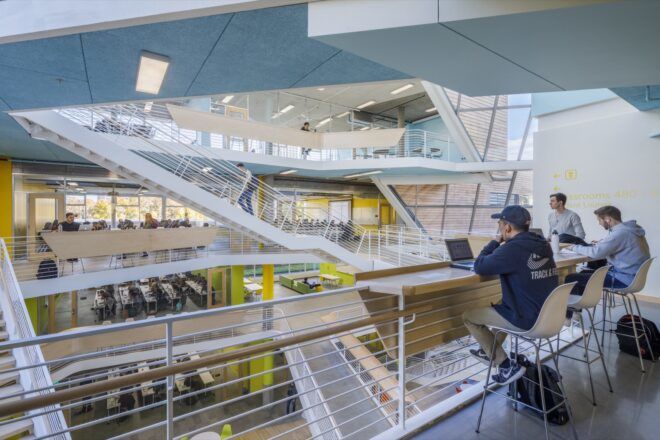 college students sitting at desk on balcony overlooking double-height lobby