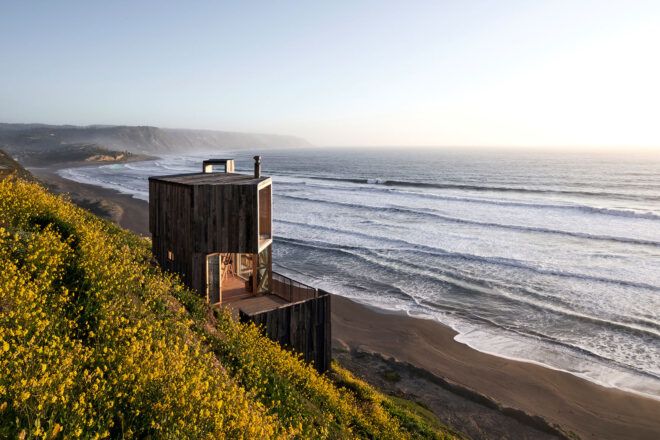 wood cabin on hillside beside a beach