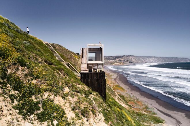 black and white wood cabin beside the ocean