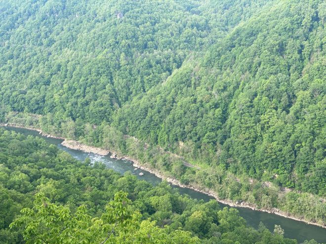 aerial view of water between two tree-covered mountains