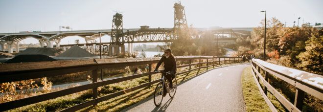 person riding bike on trail through a park