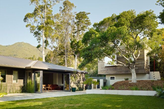 long wood and white home with doors open to yard