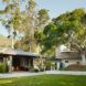 long wood and white home with doors open to yard