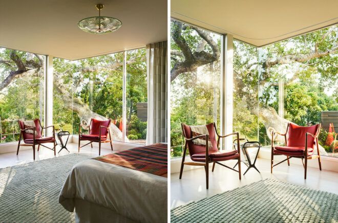 bedroom with two red chairs near glass walls