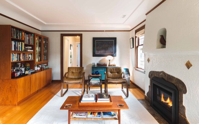 white living room with leather chairs and fireplace