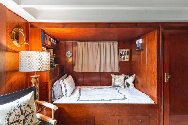 bedroom with wood walls and bed nook built into wall