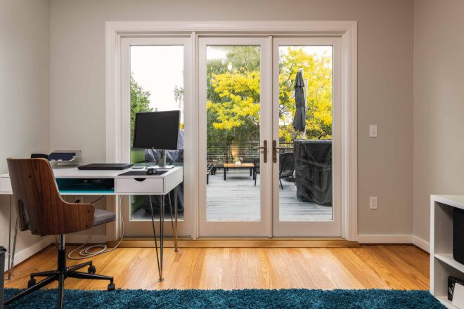 white desk facing glass wall leading to rooftop deck