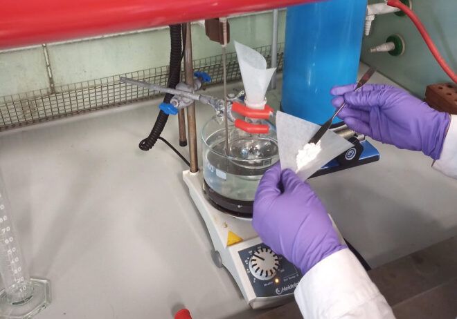 person scooping white material into paper scoop