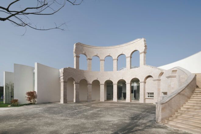ancient Roman archways in front of large white building