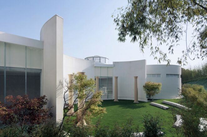 ancient columns in courtyard next to large white building