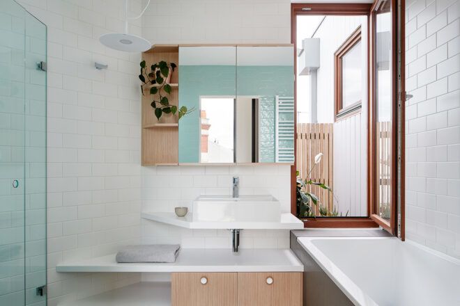 white bathroom with light wood cabinets