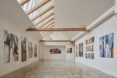 white room with wood beams and art on walls