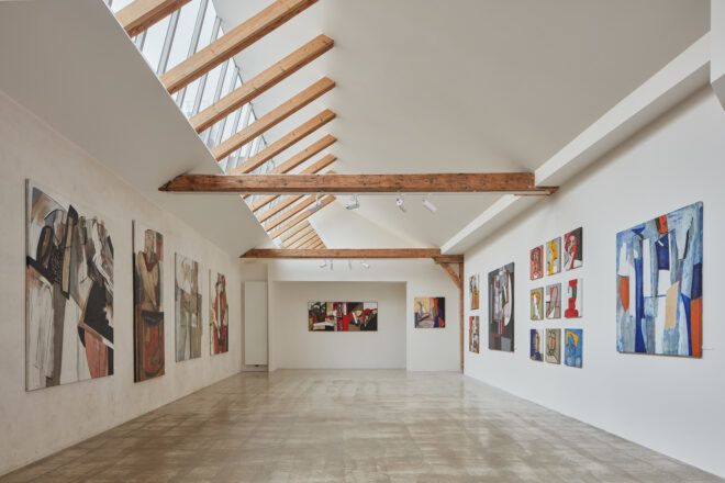 white room with wood beams and art on walls