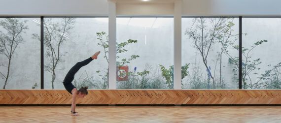 person doing handstand in large white room