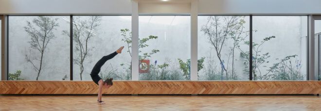 person doing handstand in large white room