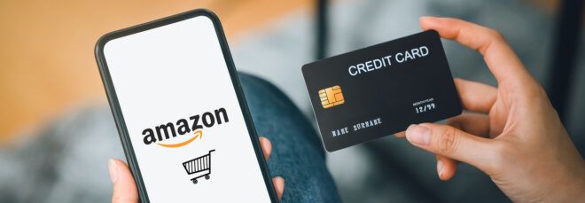 person holding phone shopping on Amazon in one hand and a credit card in the other hand
