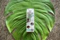 A carton of water resting on a green leaf background.
