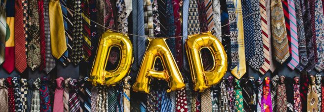 balloons spelling out "Dad" on background of neckties