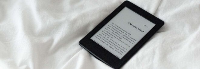 e-reader on white bed