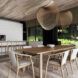A neutral-toned dining room with lights made of woven wood strips hanging over a wood dining table and chairs.