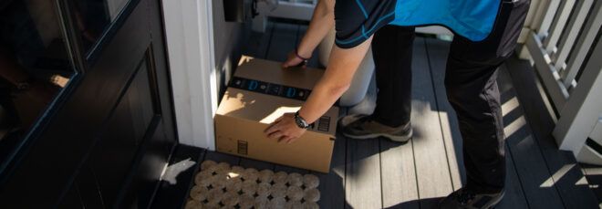 Amazon worker placing package on porch