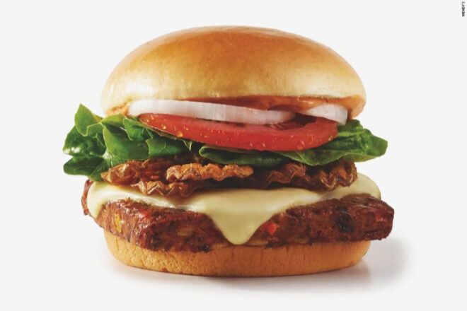 The Wendy's black bean burger stacked up with tomato, onion, lettuce, bacon and cheese.