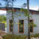 The back of a curved concrete home with an overhang and three narrow windows.