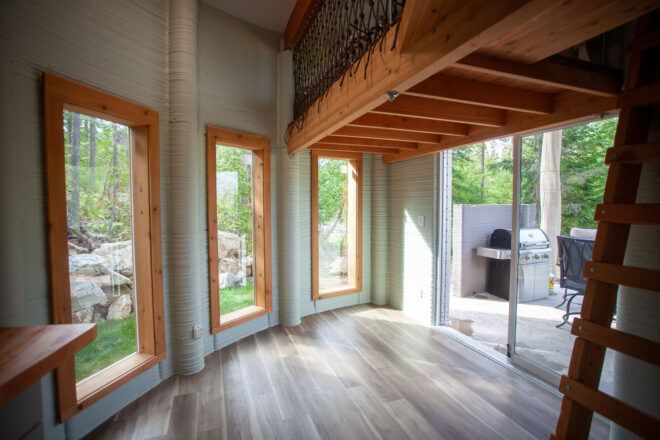The interior of the home's foyer, showing wood accents and three large windows.