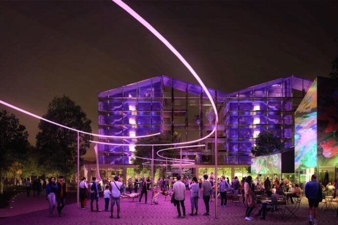 An outdoor courtyard at night, lit up by purple lights.