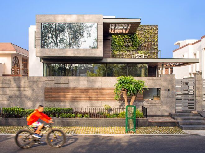 concrete cantilevered house covered in plants