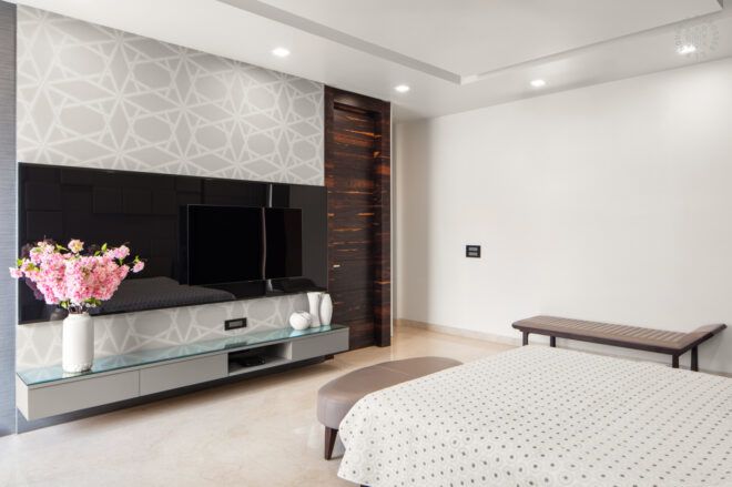 white bed facing mounted flat screen TV