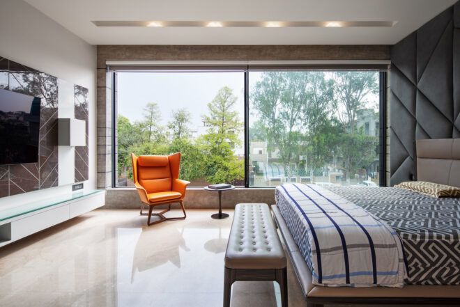 gray bed in room with large windows