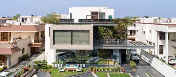 concrete cantilevered house covered in plants