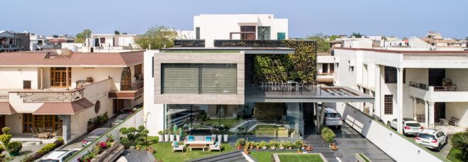concrete cantilevered house covered in plants