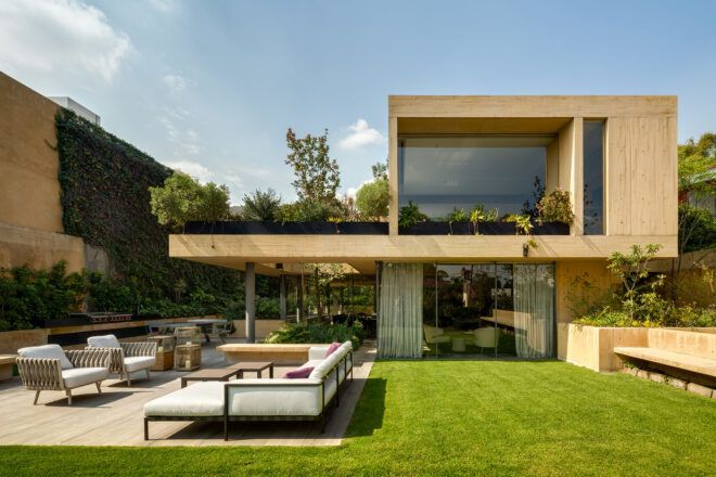 white patio furniture near cantilevered tan home