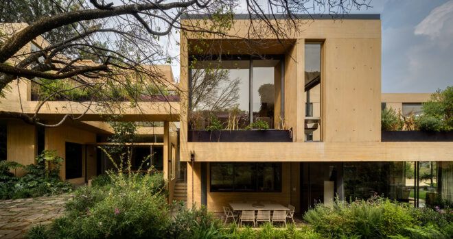 tan home with massive windows and green roofs
